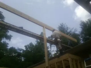 Carpenter setting a ridge beam over a new addition frame — Ice Dam Removal by Roofing Brothers in Wallis