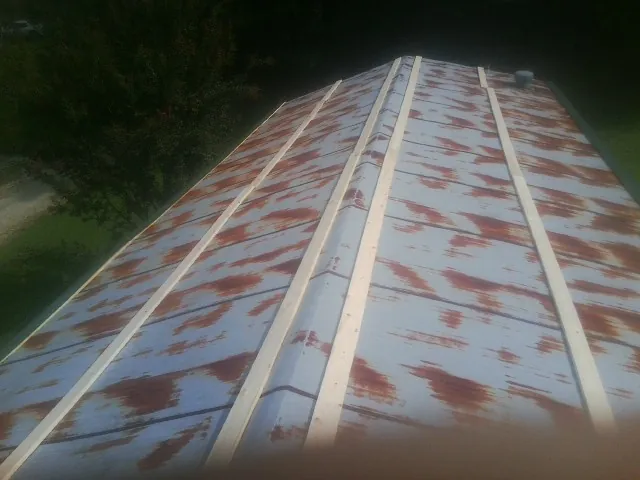 Rusted metal roof panels with new wood purlins before replacement — Storm Damage Roof Repair in Wallis by Roofing Brothers